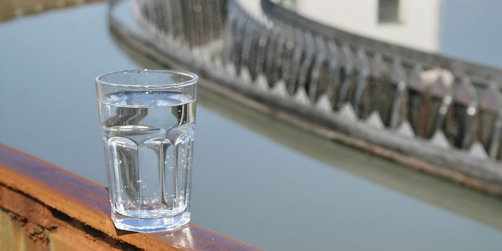 Glass of water on a ledge overlooking water treatment.